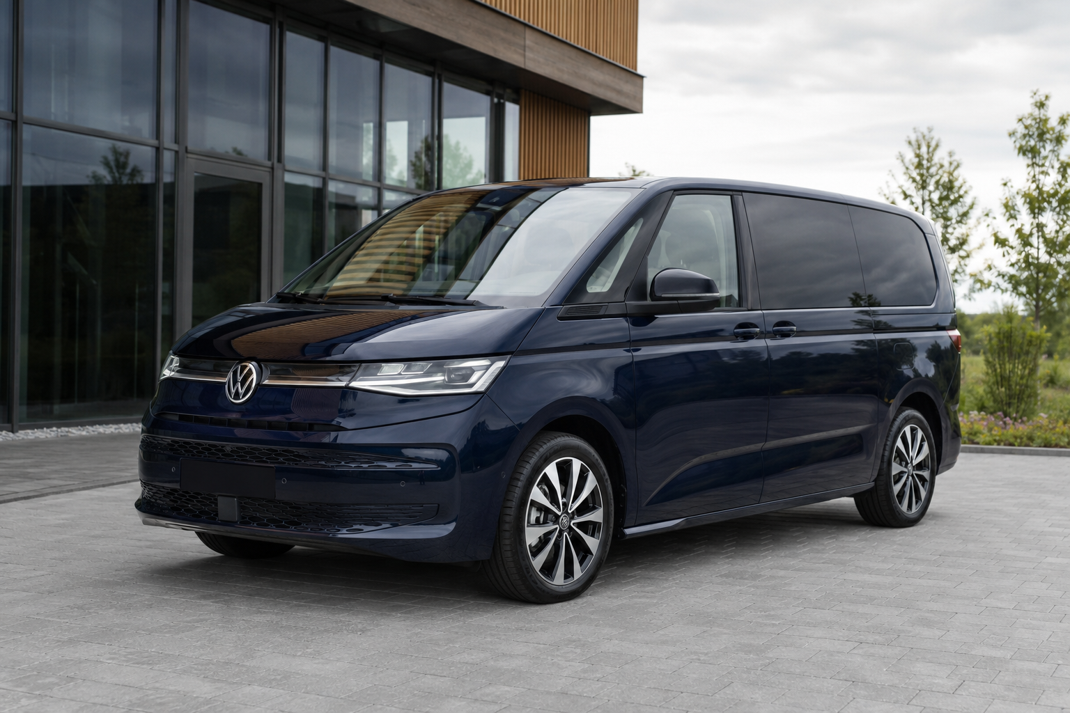 Tmavě modrý Volkswagen Multivan před moderní budovou